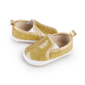 Nahaufnahme gold glitzernde Lauflernschuhe für Babys mit weißer weicher Sohle
