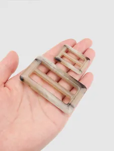 High-end urea resin buckles with marble texture held in hand for size comparison
