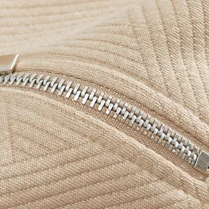Primo piano della cerniera in metallo su tessuto jacquard per felpa retrò americana.