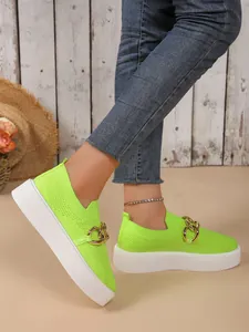 Leuchtend neongrüne Strick-Plateau-Sneaker mit grober Goldkette, am Modell präsentiert.