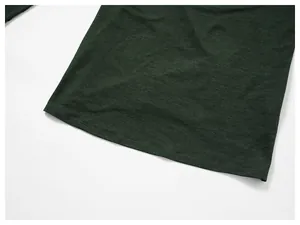 Detailed close-up of dark green athletic shirt hem with professional stitching