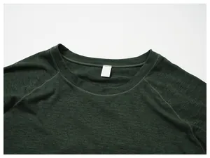 Close-up of raglan sleeve stitching and collar on a green athletic quick-dry shirt.
