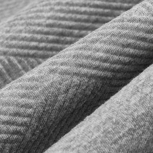 Gros plan détaillé du tissu gris épais de ce sweat-shirt avec une texture jacquard rétro
