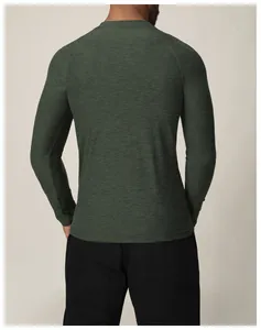 Vue arrière d'un homme portant un t-shirt de sport à manches longues vert foncé et respirant.