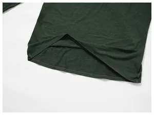 Close-up detail of the durable hem stitching on dark green men's athletic long sleeve shirt.