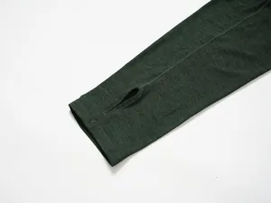 Close-up detail of the sleeve cuff with integrated thumbhole on dark green sport top