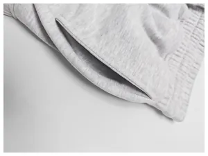 Zoom sur la poche et la texture du tissu d'un short de sport en molleton gris pour homme