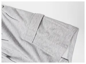 Détail de la poche cargo et de la texture douce du tissu d'un short de sport gris pour homme