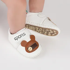 Vista dettagliata di scarpe da camminata bianche per neonati con design a orsetto