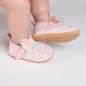Detail view of pink floral baby walking shoes with elegant white mesh bow decoration.