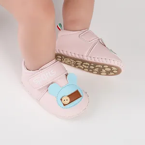 Dettaglio scarpe da camminata rosa per neonati con grazioso orsetto blu e chiusura a strappo