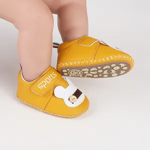 Dettaglio di scarpe da passeggio gialle per neonati con design a coniglio e velcro