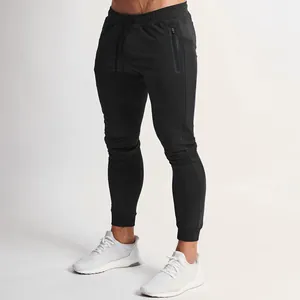 Close-up of men's black slim-fit athletic joggers with zippered side pockets.