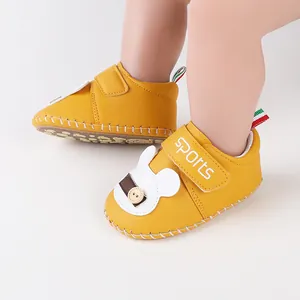 Dettaglio di scarpine primi passi gialle con motivo a coniglio e cinturino SPORTS