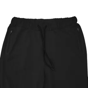 Detailed view of the elastic waistband and drawstring on black men's gym sports pants.