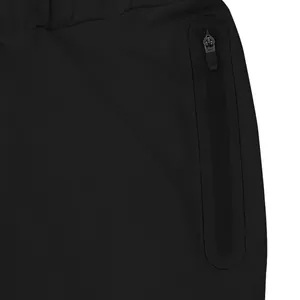 Macro detail of a hidden zipper pocket with heat-sealed edges on black men's sports pants.