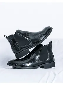Primer plano de botines Chelsea para hombre en cuero grabado negro con paneles elásticos