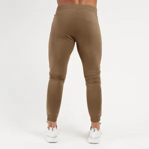 Back view of brown slim fit men's sports joggers with elastic waistband for gym
