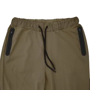 Close-up of men's athletic pants waistband with black drawstring and zip pockets