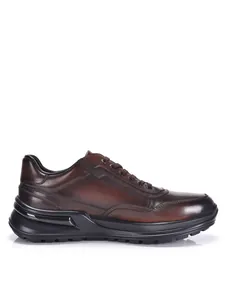 Seitenansicht stilvoller dunkelbrauner Herrenschuhe aus Leder mit einer dicken schwarzen Sohle