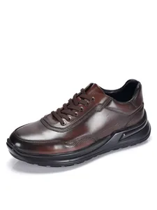Detailansicht brauner Herren-Lederschuhe mit dicker schwarzer Sohle und Schnürung