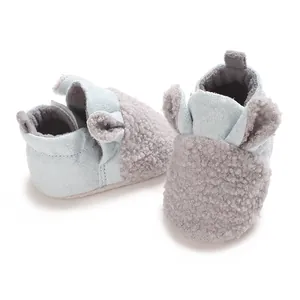 Nahaufnahme niedlicher Teddy-Fleece-Babylauflernschuhe in hellblauer und grauer Farbe