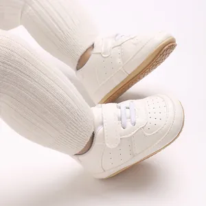 Primo piano di scarpe bianche da bambino in ecopelle PU traspirante con chiusura a strappo.