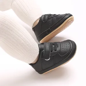Dettaglio scarpe da ginnastica in PU nero per neonati con suola in gomma antiscivolo.