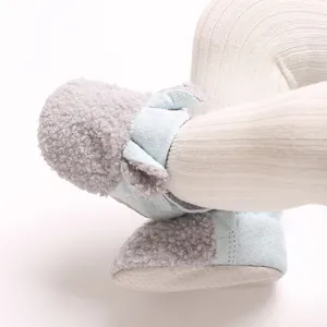 Detailaufnahme gemütlicher Baby-Booties aus Teddyvlies mit süßer Schleife und weicher Sohle