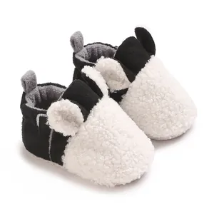 Nahaufnahme von niedlichen schwarz-weißen Teddy-Fleece-Babyschuhen mit weichem Ohr-Dekor