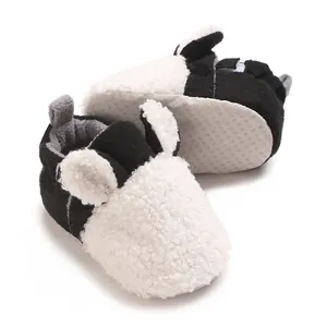 Detail von süßen Baby-Winterschuhen mit weißem Teddy-Fleece und schwarzen Akzenten