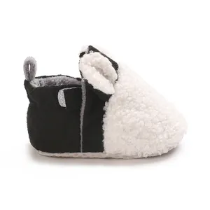 Detailansicht niedlicher schwarz-weißer Baby-Winterschuhe aus flauschigem Teddy-Fleece