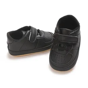 Primo piano di scarpe da ginnastica nere in pelle PU per neonati con cinturino velcro