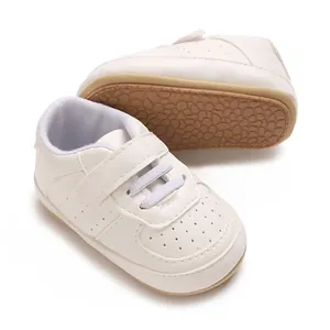 Dettaglio delle scarpe bianche da ginnastica per neonati con suola in gomma morbida