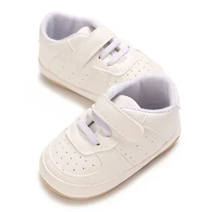 Dettaglio macro di scarpe da ginnastica per neonati in pelle PU bianca traspirante con suole morbide