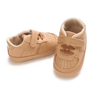 Dettaglio di sneaker per neonati in pelle PU marrone chiaro con suole in gomma antiscivolo.