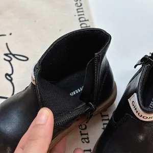 Detailed view of the side zipper and soft interior lining of black toddler boots.