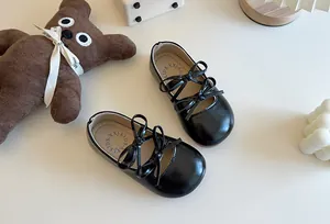 Dettaglio delle scarpe in vernice nera per bambina con eleganti accenti a doppio fiocco