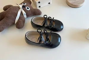 Primo piano di ballerine nere da bambina con doppi fiocchi e suola morbida in pelle