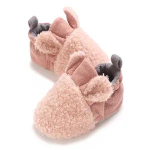 Nahaufnahme von süßen rosa Teddy-Fleece-Babystiefeln mit weichen Details aus Hasenohren