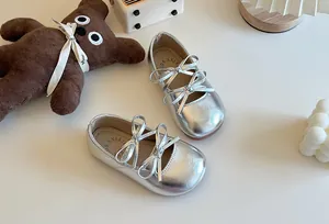 Dettaglio delle ballerine argentate da bambina con graziosi fiocchi doppi a forma di farfalla.