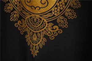Close-up of gold metallic foil ethnic print on black fabric of men's robe shirt