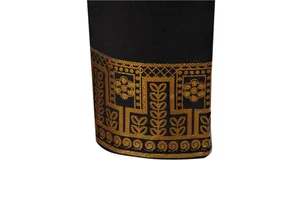 Close-up detail of traditional gold foil ethnic pattern on black long robe shirt sleeve
