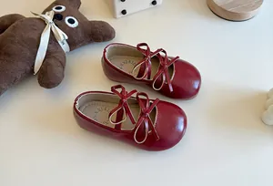 Dettaglio di ballerine rosse da bambina con elegante design a doppio fiocco e finitura lucida