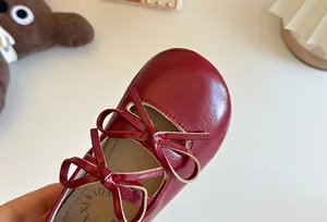 Dettaglio di ballerine rosse per bambina con doppio fiocco decorativo in pelle morbida