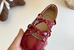 Primo piano di ballerina rossa da bambina con elegante decorazione a doppio fiocco.