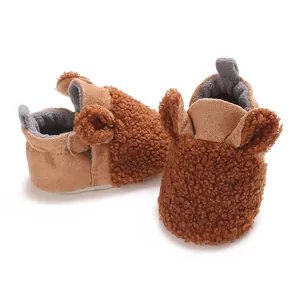 Nahaufnahme der braunen Teddy-Fleece-Babyschuhe für den Winter mit niedlichen Bärenohren