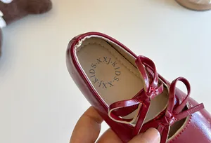 Primo piano dettagliato di una ballerina in pelle bordeaux per bambina con fiocco