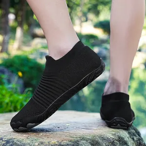 Detailopname van zwarte vijfvingerige blotevoetenschoenen voor buitenactiviteiten op rotsen