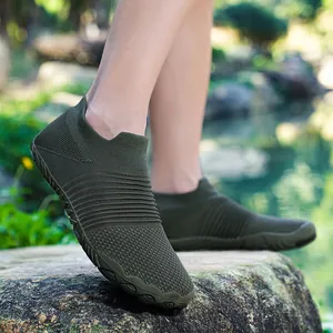 Gedetailleerd overzicht van olijfgroene gebreide minimalistische outdoorschoenen op een rots